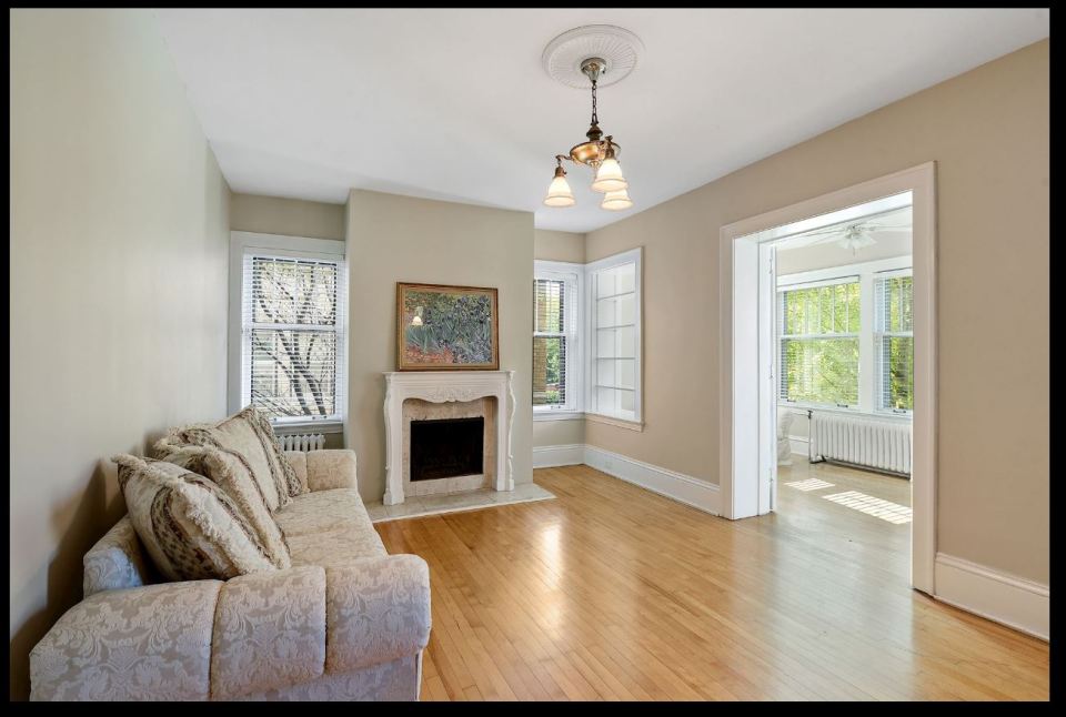 View of living room with wood fireplace and attached sun room